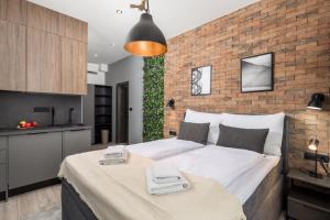 a bedroom with a large bed and a brick wall at Mila apartments in Rijeka