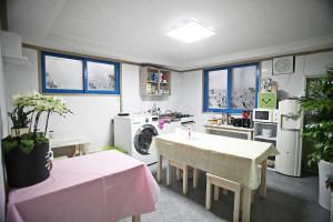 a kitchen with a table and a washing machine at Dadam Guesthouse in Yeosu