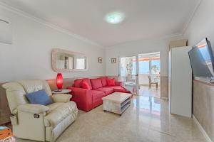 a living room with a red couch and a tv at Apartment in El Paso in Arona
