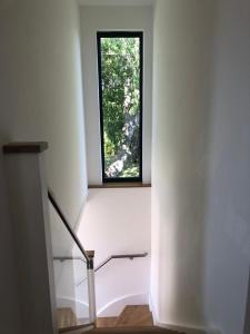 a staircase with a window in a white building at Cannister Hall Apartment, Selling, Faversham, Kent in Faversham