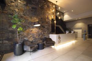 a lobby with two chairs and a stone wall at 2505 Studio in Central Cape Town, Wi-Fi, pool, free parking in Cape Town +12 photos