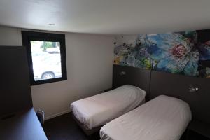 a small room with two beds and a window at Brit Hotel Montpellier Eurom&eacute;decine in Montpellier
