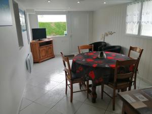 a dining room with a table and chairs and a television at gîte vacances in Moncontour