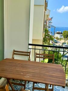 a wooden bench on a balcony with a view of the ocean at Yosun Apart in Kaş
