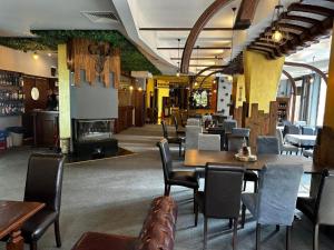 a restaurant with tables and chairs and a fireplace at Студио в Хотел Айсберг in Borovets