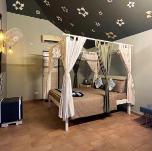 a bedroom with a bed with a canopy at The Village Resort in Kodāe +22 photos