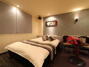 a hotel room with a bed and a table at Hotel La Siesta (Adult Only) in Kyoto
