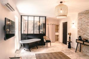 a bathroom with a bath tub and a window at Les Suites de l'Étang in Cucuron