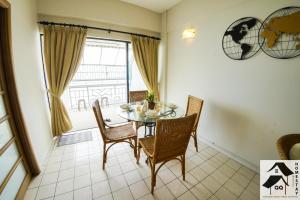a dining room with a table and chairs and a window at Nice Seaview Apartment with 2R1B in Port Dickson +6 photos