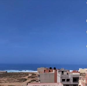 un edificio sulla spiaggia con l'oceano sullo sfondo di Dar Aglou Appart 2 a Aglou