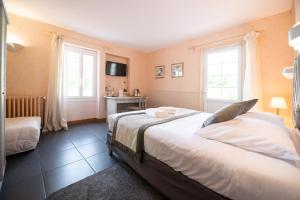 a bedroom with a large bed and two windows at Logis Hôtels - Hôtel Restaurant Domaine Les Falaises in Martel +92 photos