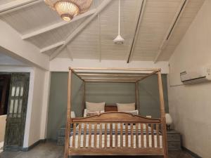 a wooden bed in a room with a ceiling at Nagenahira Beach Villa in Nilaveli