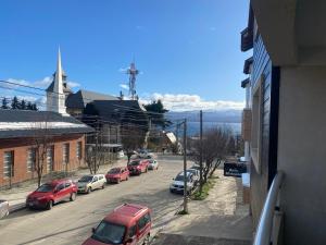un groupe de voitures garées dans une rue avec une église dans l'établissement Los Amancay del Centro, à San Carlos de Bariloche