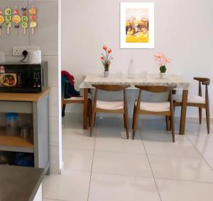 a dining room with a table and chairs and a microwave at Mid Night Realm Kuala Lumpur in Kuala Lumpur