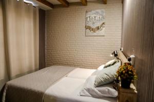a bedroom with a bed and a brick wall at Sfeervolle bungalow op vakantiepark Baarland in Baarland