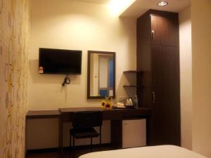 Cukai的住宿－世紀酒店，卧室配有一张桌子,墙上配有电视