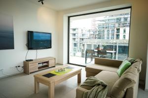 TV a/nebo společenská místnost v ubytování Huswell - Beautiful apartment with communal pool and gym