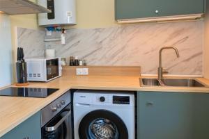 a kitchen with a washing machine and a sink at Chill and Work en Drome in Saint-Rambert-dʼAlbon