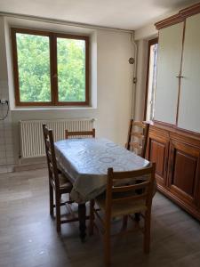 a dining room with a table and chairs and a window at 100metres du château au 116 Rue de la République vizille in Vizille +1 photo