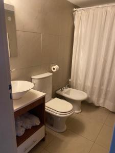 une salle de bain blanche avec toilettes et lavabo dans l'établissement Los Amancay del Centro, à San Carlos de Bariloche 5 autres photos