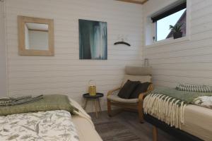 a bedroom with two beds and a chair and a window at 3ART recreation in Tromsø