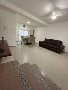 a living room with a couch and a table at Riviera de Garopaba Unidade Azure - A Beira Mar in Garopaba