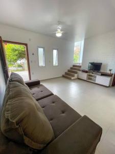 a living room with a couch and a tv at Riviera de Garopaba Unidade Azure - A Beira Mar in Garopaba +64 photos
