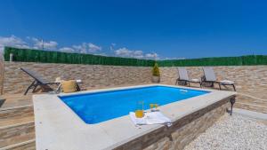 a swimming pool with two chairs and a table at Casa Maria de Velez Almayate Alto by Ruralidays in Almayate Alto