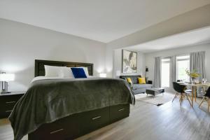 a bedroom with a large bed and a living room at Horseshoe Valley Bliss - Luxe Condo Retreat with Jacuzzi - Top Floor Romance - Self-Check-in - Indoor & Outdoor Heated Pool Haven in Shanty Bay +59 photos