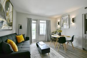 a living room with a couch and a table at Horseshoe Valley Bliss - Luxe Condo Retreat with Jacuzzi - Top Floor Romance - Self-Check-in - Indoor & Outdoor Heated Pool Haven in Shanty Bay
