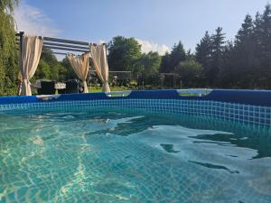 a large swimming pool with a blue tiled at Przy potoku in Średnia Wieś