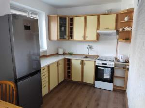 a kitchen with yellow cabinets and a black refrigerator at Apartament u Łukasza in Mrągowo