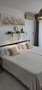 a bedroom with a large white bed with pillows at Hotel Los Narejos in Los Alc&aacute;zares