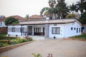 a white house with a courtyard in front of it at JIREH Residence in Kigali