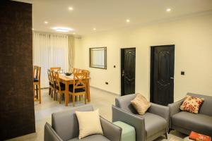 a living room with a table and chairs and a dining room at JIREH Residence in Kigali