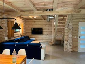 a living room with a blue couch and a table at Domek nad jeziorem Agnieszka i Radek Sieczkowscy in Harsz