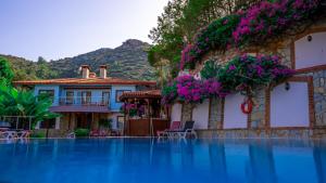 a house with flowers on the side of a swimming pool at Selimiye Meltem's in Marmaris