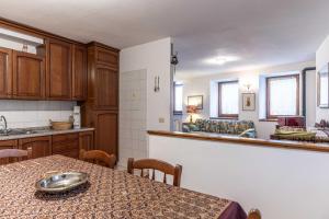 a kitchen with a table and a dining room at Casa Rita, Altopiano di Piné Ospitar in Pergine Valsugana