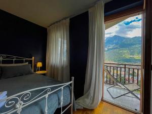 une chambre avec un lit et une grande fenêtre dans l'établissement L'Atelier du Temps - BellAosta Home, à Aoste