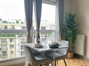 a dining room table with chairs in front of a window at Brand-new studio with Eiffel Tower view in Paris +15 photos