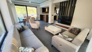 a living room with two white couches and a television at Villa Ala A4 Özel Havuzlu in Dalaman
