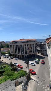 a large building with cars parked in a parking lot at Fogar do Freixo - by entreRías in Cangas de Morrazo