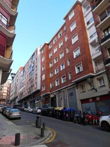 a city street with tall buildings and parked cars at Akelarre in Bilbao