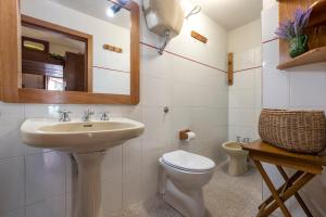 a bathroom with a sink and a toilet and a mirror at Casa al mare con ampia veranda in Stintino