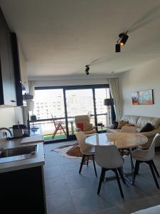 een keuken en woonkamer met een tafel en stoelen bij EnJOY Zee en uitzicht op Hinterland Westende in Middelkerke