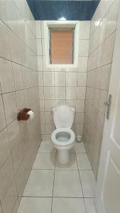 une salle de bain avec toilettes et fenêtre dans l'établissement Kaze Bretagne - Évasion à Saint-Denis - Charmante Maison T3 avec Terrasse, Jardin et Vue Imprenable - Proche Aéroport, à Saint-Denis 2 autres photos