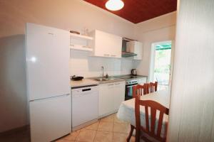 a kitchen with a white refrigerator and a table at Morska in Orebić