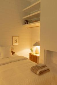 a bedroom with a bed and a table with a lamp at Herrings House, an iconic designer nature retreat in Willunga +63 photos
