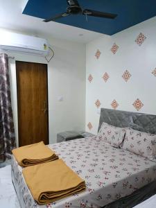 a bedroom with a bed and a ceiling at Naramada Homestay Rooms in Garudeshwar