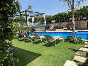 a group of chairs sitting next to a swimming pool at Grand Alaçatı Butik Hotel in Alaçatı